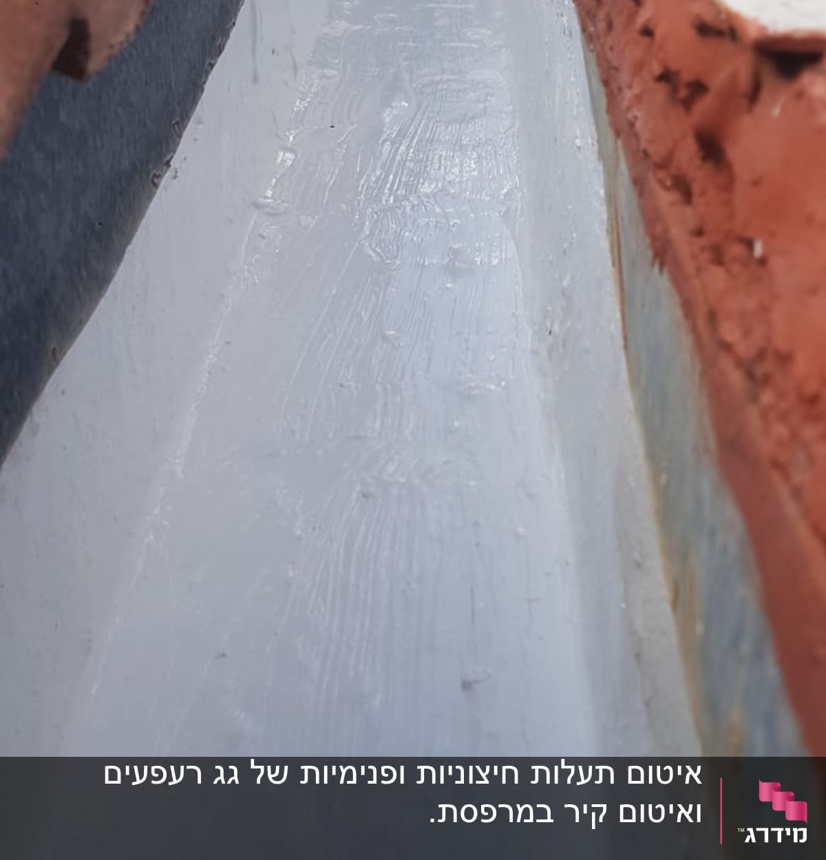 איטום גג עם חומר לבן בין רעפים